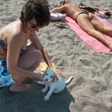Mujer con cachorro en la playa.