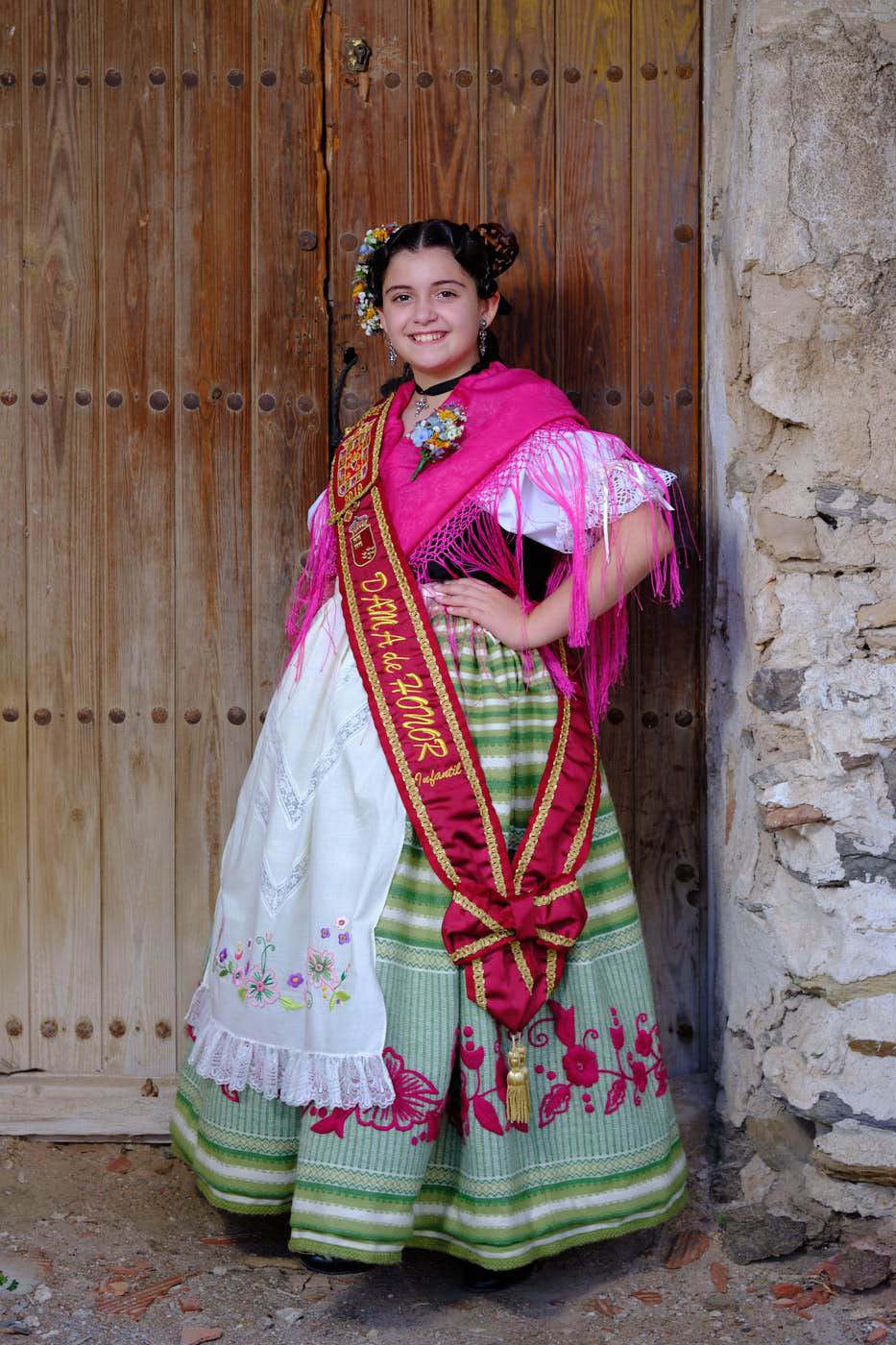 Foto de niña dama de la huerta infantil con traje regional murciano en la puerta de una casa antigua